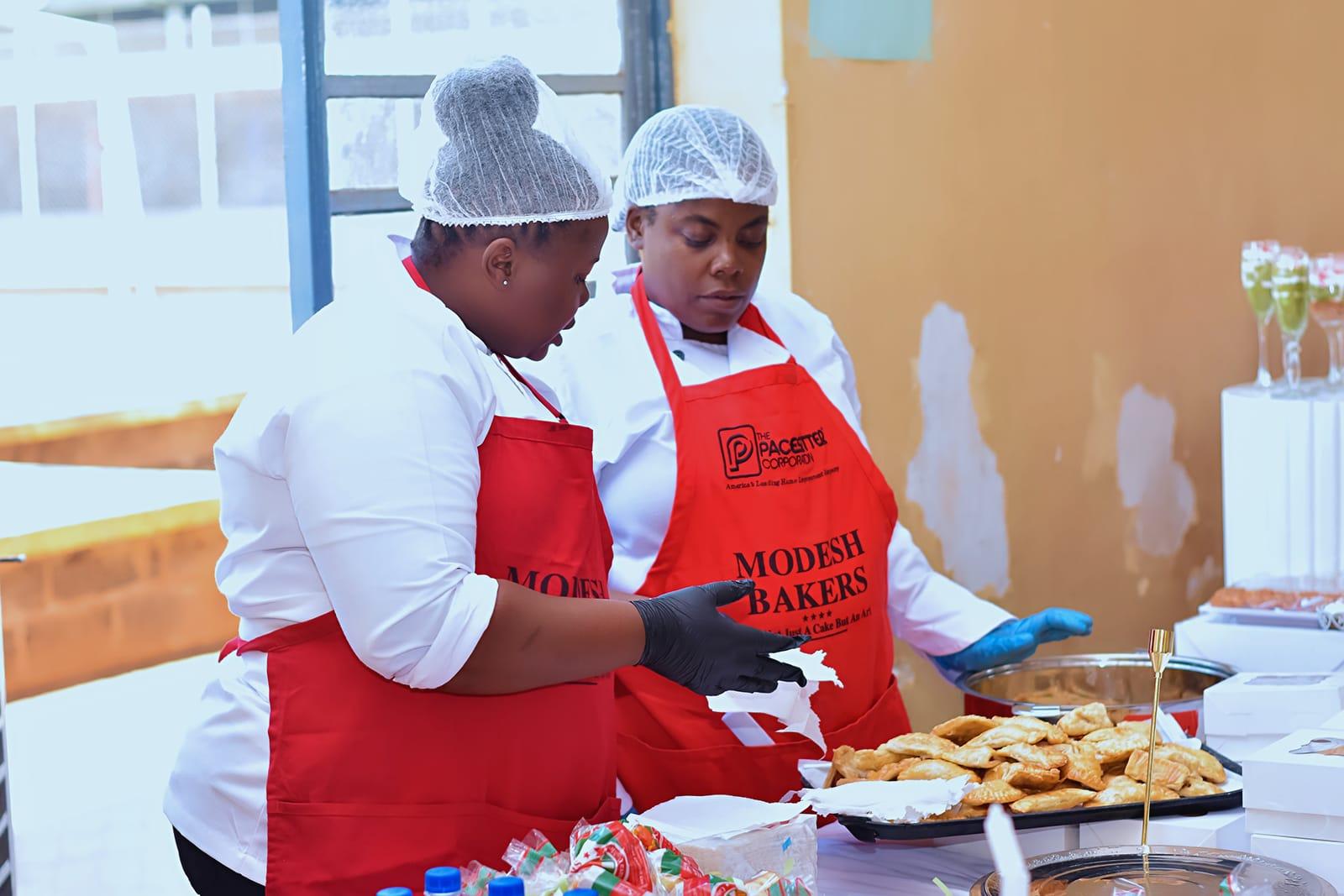 Modesh bakers in aprons plating fresh pastries at an event